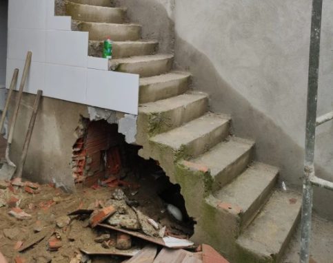 Body of missing woman found buried in a concrete wall beneath a staircase